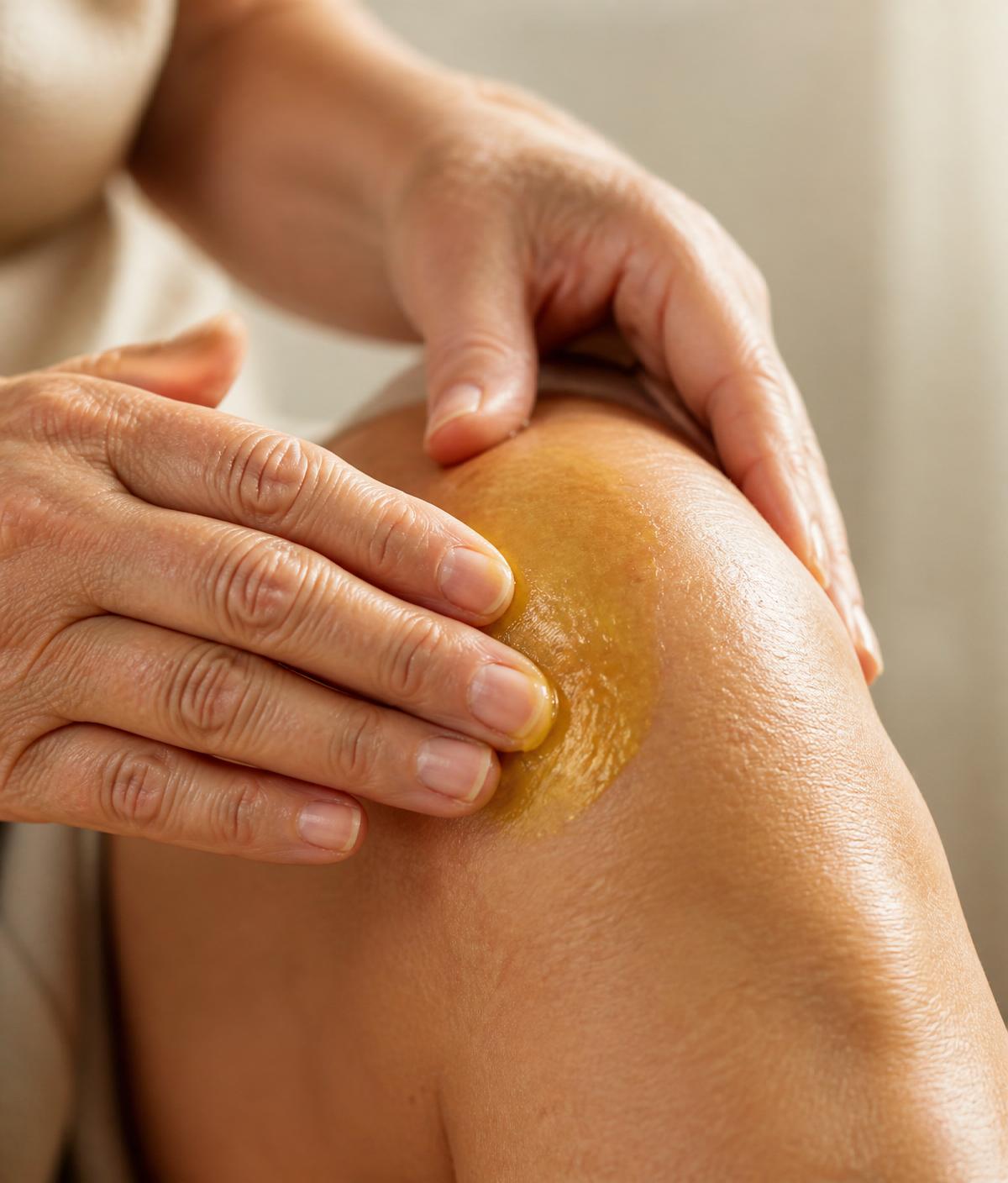 Hands massaging TheraWolf Relief Balm into a knee joint